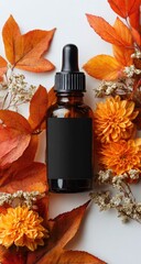 Amber glass bottle with black label, surrounded by autumnal leaves and orange flowers on a white background