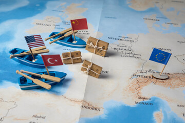 A detailed map of the world shows miniature ships flying the flags of various countries (the USA, China, Turkey, and the European Union) and small parcels