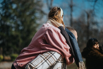 Fototapeta premium A joyful group of friends enjoying a fun moment outdoors in a scenic park setting. The atmosphere is lively, showcasing connections and happiness within a natural and tranquil environment.