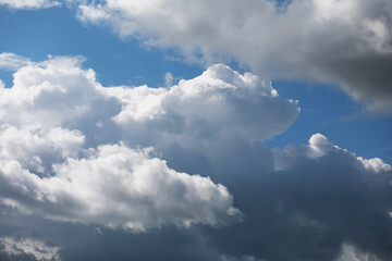 Fluffy Cumulus Clouds Against Blue Sky with Contrast of Dark Storm Clouds