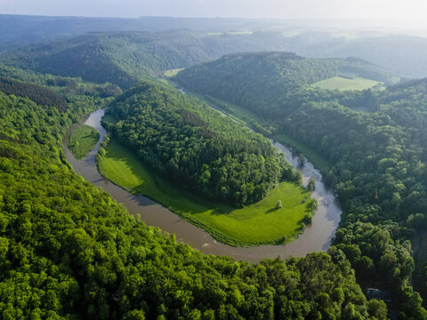 Aerial view of the winding Semois River embracing lush green forests near Moulin du Rivage, a verdant embrace of nature's artistry, Bouillon, R&Atilde;&copy;gion wallonne, Belgium.