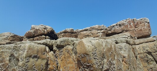 Rugged coastal rocks under clear blue sky