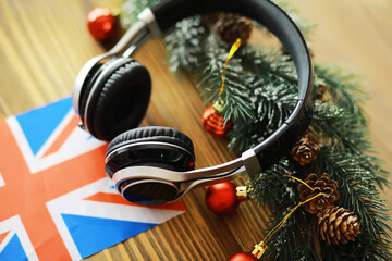 Holiday-Themed Headphones with British Flag and Christmas Decorations on Wooden Table