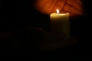 ** Illuminated Hand Holding Candle in Dark Room for Tranquility and Reflection Meditation