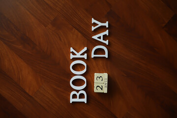 Book Day Celebration with Wooden Calendar and 3D Letters on Wooden Floor Background