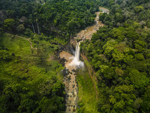 Aerial view of the Ekom-Nkam Waterfalls cascading down rugged cliffs, amidst a symphony of emerald and jade foliage, Nkongsamba, Littoral Region, Cameroon.