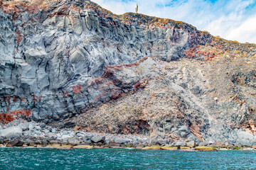 Mexican coastline with eroded slope and volcanic lava rock formations, cacti on top, Coronado Island Protected Area, Loreto Bay National Marine Park in Baja California Sur, Mexico