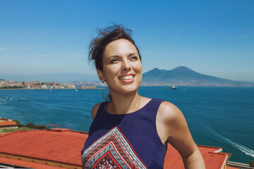 Young brunette woman smiles, enjoying the breathtaking view of famous Mount Vesuvius