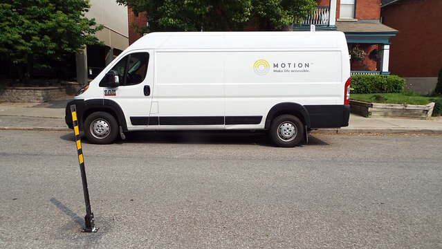 Ottawa, ON, Canada-July 23,2025: A white Ram ProMaster van, branded with the "MOTION Make life accessible" logo, is parked on Sussex drive.

