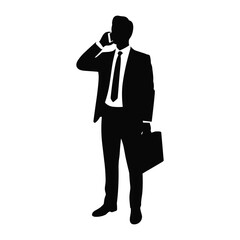 Silhouette of a businessman in a suit talking on a mobile phone holding a briefcase