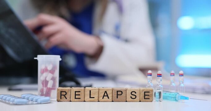 Doctor reviews X-ray at desk with Relapse on blocks and pills on desk. Serious medical and psychological problem of relapse associated with addiction
