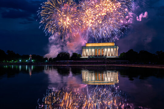 spectacular patriotic celebration fireworks bursting over lincoln memorial reflecting in potomac river at twilight