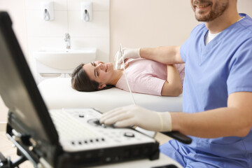 Obraz premium Sonographer conducting ultrasound examination of woman's thyroid gland in clinic, closeup