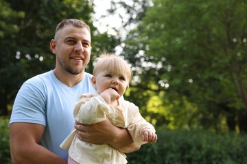 Fototapeta premium Smiling dad and his baby outdoors, space for text. Happy Father's Day