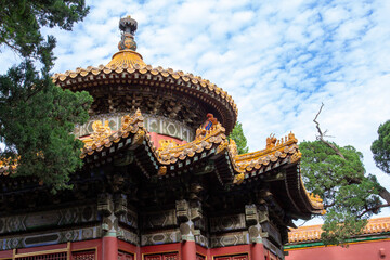 Fototapeta premium Traditional Chinese Palace Architecture with Red Wall and Ornate Roof Against Blue Sky, Beijing Forbidden City Style