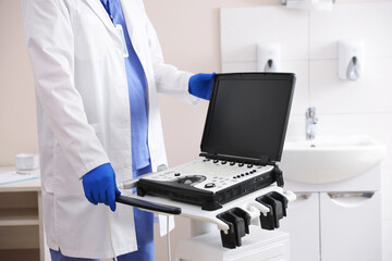 Professional sonographer with ultrasound machine in clinic, closeup