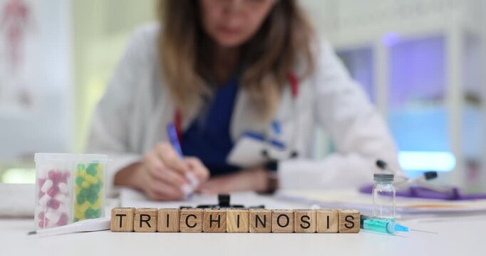 Trichinosis on wooden blocks and pills on desk with female medical professional writing. Parasitology diagnosis and treatment of parasitic disease
