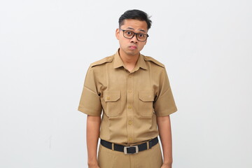 Frustrated Indonesian civil servant man standing with sad face expression