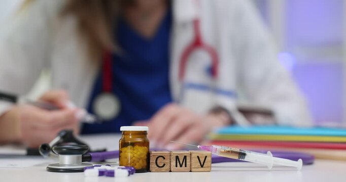 Female doctor reviews documents near CMV on wooden blocks and bottle of pills on desk. Virology diagnosis and treatment related to Cytomegalovirus