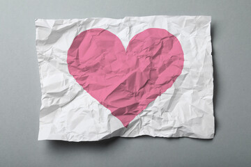 Obraz premium Betrayal. Crumpled sheet of paper with pink heart on grey background, top view