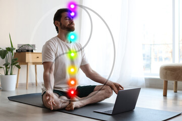 Man meditating in Lotus pose at home. Seven chakras glowing. Yin-yang symbol around him