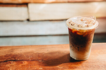 Refreshing Iced Coffee in Clear Plastic Cup on Wooden Table