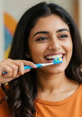 smiling young middle eastern or indian woman brushing teeth with colorful toothbrush. personal hygiene and dental care concept. healthy lifestyle, morning routine. healthcare website poster.