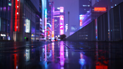 Blurred city street at night with colorful neon lights reflecting on wet pavement