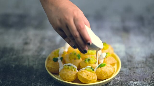 Close up of Indian street food fuchka on a plate glass with sour spicy water. Dahi Pani puri a chat item in India. 4K indian street food snacks.