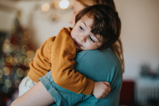 A tender moment of a mother holding her young child close, depicting comfort, care, and love in a warm and peaceful environment.