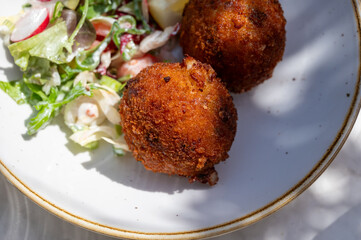 Lunch in cafe with vegetarian cheese and green asparagus croquettes served with fresh salad and french fries potato in Bruges, Belgium
