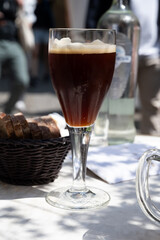 Belgian beer in glass in old brewery in Bruges, dubbel dark, tasty beverage, lunch with beer, tourist destination, Flanders, Belgium