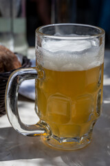 Belgian beer in glass in old brewery in Bruges, light or dark, tasty beverage, lunch with beer, tourist destination, Flanders, Belgium
