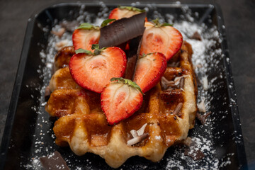 Baked belgian sugar waffles with various toppings, delicious sweet street food in Bruges, Flanders, Belgium