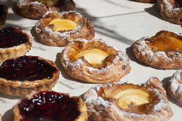 Fresh baked buttered fruit and sweet buns, cakes, pastries in artisan bakery early morning in Bruges, Belgium