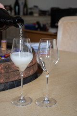 Pouring in glass of white sparkling wine brut, grand reserve, champagne in Ay-Champagne old grand cru wine making village in Vallee de la Marne, Champagne, France