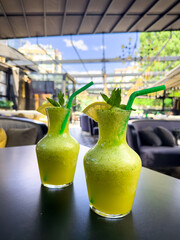 Chilled lemonade glasses with mint on modern black table. summer refreshment. citrus drink.