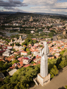 Aerial view of the iconic Kartlis Deda statue overlooking the vibrant cityscape with the Holy Trinity Cathedral in the distance, Tbilisi, Tbilisi, Georgia.