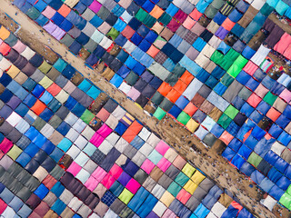 Aerial view of vibrant patchwork of colorful tents sprawling across the landscape, creating a striking contrast against the sandy pathways, Dhaka, Dhaka Division, Bangladesh.
