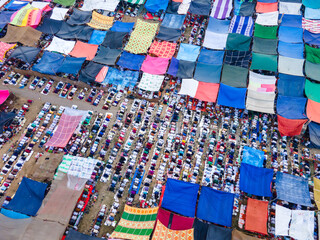 Aerial view of a vast gathering, shadows stretching long under makeshift canopies, creating a mosaic of colors and textures in the open space, Dhaka, Dhaka Division, Bangladesh.