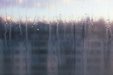 Window with condensation on it and a blurry background. Scene is somewhat melancholic and contemplative
