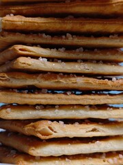 Stacked Salted Crackers CloseUp of Crispy Texture and Sparkling Salt Crystals.