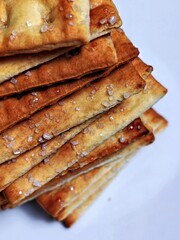 Stacked Salted Crackers Golden Brown Texture and Crystalline Salt Detail.