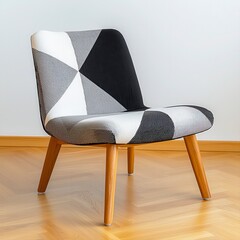 A stylish slipper chair features a modern minimalist geometric pattern in black and white tones on its upholstered seat and back with light wood legs.