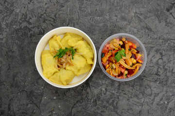 set of mashed potatoes with onions and herbs and salad vinaigrette with mushrooms in disposable dishes