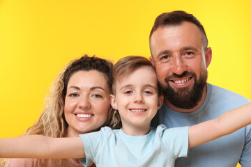 Fototapeta premium Portrait of happy family on yellow background