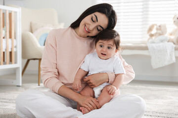 Happy mother with her cute little baby at home