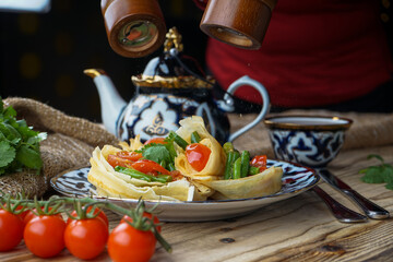 pancakes with tomatoes and asparagus wrapped in boats and sprinkled with pepper