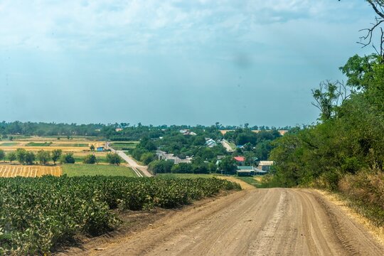 the entrance to a kuban village in southern russia surrounded by fields of agricultural crops on a hot midsummer day