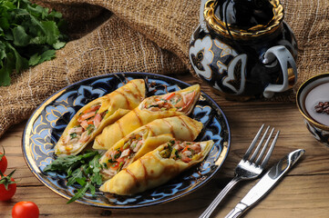 pancakes with filling wrapped in rolls on the background